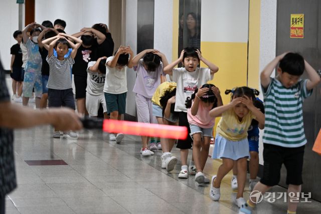 2025 을지연습과 연계한 공습 대비 민방위훈련이 실시된 20일 오후 수원 효동초에서 공습경보 사이렌 속에 학생들이 머리를 감싼 채 대피장소로 이동하는 등 실전 같은 훈련을 하고 있다. 김시범기자