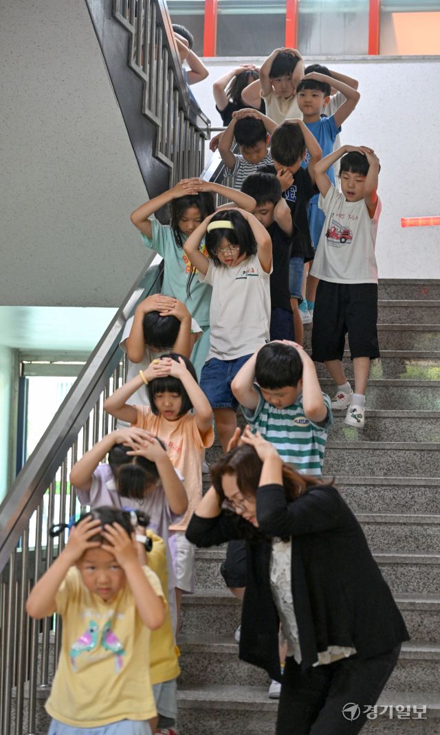 2025 을지연습과 연계한 공습 대비 민방위훈련이 실시된 20일 오후 수원 효동초에서 공습경보 사이렌 속에 학생들이 머리를 감싼 채 대피장소로 이동하는 등 실전 같은 훈련을 하고 있다. 김시범기자