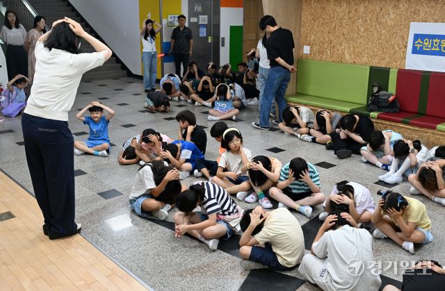 2025 을지연습과 연계한 공습 대비 민방위훈련이 실시된 20일 오후 수원 효동초에서 공습경보 사이렌 속에 학생들이 머리를 감싼 채 대피장소로 이동하는 등 실전 같은 훈련을 하고 있다. 김시범기자