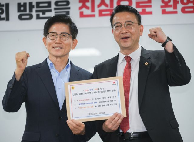 국민의힘 김문수 당대표 후보가 백현종 경기도의회 국민의힘 대표의원으로부터 현안 건의서를 건네받고 기념촬영을 하고 있다.조주현기자