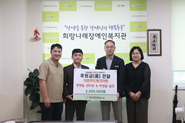 의왕 희망나래장애인복지관 백상훈 관장(오른쪽 두번째)과 마포행복나눔푸드마켓 관계자들이 업무협약을 진행한 뒤 기념촬영을 하고 있다. 희망나래장애인복지관 제공