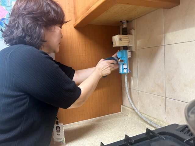 구성농협 재가노인복지센터 직원이 어르신 가정을 방문해 화재예방을 위한 가스타이머 무상장착을 지원하고 있다. 구성농협 제공