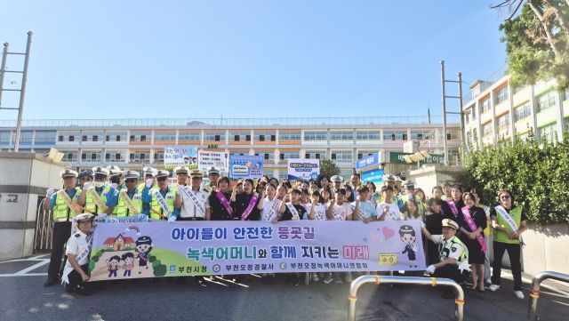 부천오정경찰서가 오정초등학교 앞에서 녹색어머니연합회, 모범운전자회, 부천시 주차지도과, 오정초 교직원·학생 등 60여 명과 함께 ‘어린이 교통안전 캠페인’을 진행한 뒤 기념촬영을 하고 있다. 부천오정경찰서 제공