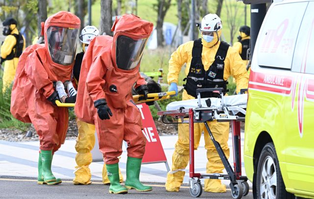 18일 인천 중구 인스파이어 리조트에서 실시된 2025 APEC(아시아태평양경제협력체) 정상회의 대비 관계기관 대테러 합동훈련에서 119 화학대응센터 구조대원들이 화학테러공격을 받은 부상자를 이송하고 있다.