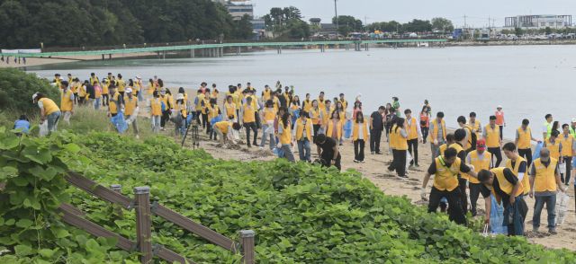 추석 연휴와 APEC 정상회의를 앞두고 정부가 추진하는 ‘대한민국 새단장 주간’이 22일 화성특례시 궁평항에서 개막식과 함께 시작됐다. 개막식에는 주민과 단체들이 참여해 해안가 쓰레기를 수거하며 전국 캠페인의 출발을 알렸다. 경기도는 이번 주간 동안 연안·시장·주거지 등 취약 구역 정비에 나설 계획이다. 사진은 이날 화성특례시 궁평항에서 열린 ‘대한민국 새단장 주간’ 개막 행사에 참여한 자원봉사자들이 해안가 쓰레기를 수거하는 모습.조주현기자