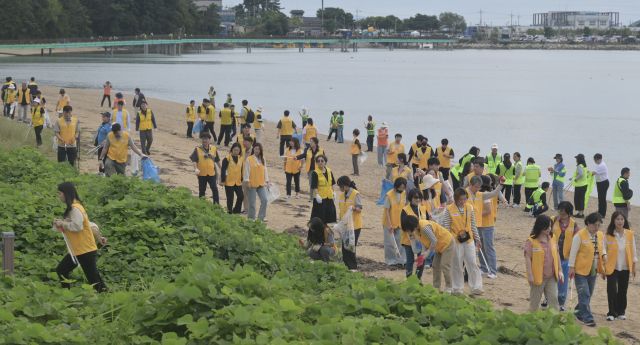 추석 연휴와 APEC 정상회의를 앞두고 정부가 추진하는 ‘대한민국 새단장 주간’이 22일 화성시 궁평항에서 개막식과 함께 시작됐다. 개막식에는 주민과 단체들이 참여해 해안가 쓰레기를 수거하며 전국 캠페인의 출발을 알렸다. 경기도는 이번 주간 동안 연안·시장·주거지 등 취약 구역 정비에 나설 계획이다. 사진은 이날 화성특례시 궁평항에서 열린 ‘대한민국 새단장 주간’ 개막 행사에 참여한 자원봉사자들이 해안가 쓰레기를 수거하는 모습.조주현기자