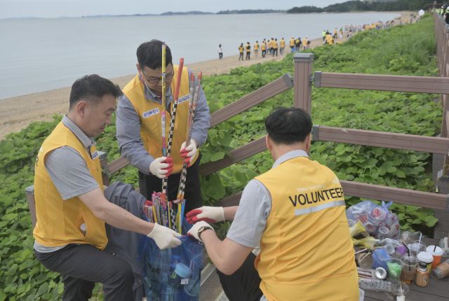 추석 연휴와 APEC 정상회의를 앞두고 정부가 추진하는 ‘대한민국 새단장 주간’이 22일 화성특례시 궁평항에서 개막식과 함께 시작됐다. 개막식에는 주민과 단체들이 참여해 해안가 쓰레기를 수거하며 전국 캠페인의 출발을 알렸다. 경기도는 이번 주간 동안 연안·시장·주거지 등 취약 구역 정비에 나설 계획이다. 사진은 이날 화성특례시 궁평항에서 열린 ‘대한민국 새단장 주간’ 개막 행사에 참여한 자원봉사자들이 해안가 쓰레기를 수거하는 모습.조주현기자