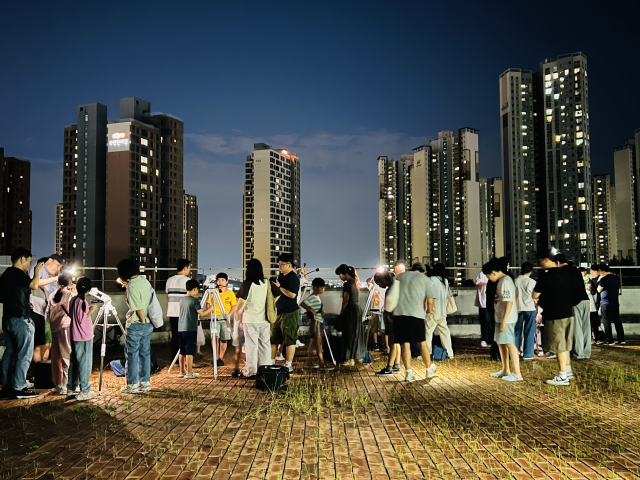 '인천에서 우주를 바라보다' 프로그램 참여자들이 직접 조립한 망원경으로 우주를 관찰하고 있다. 인천대 제공