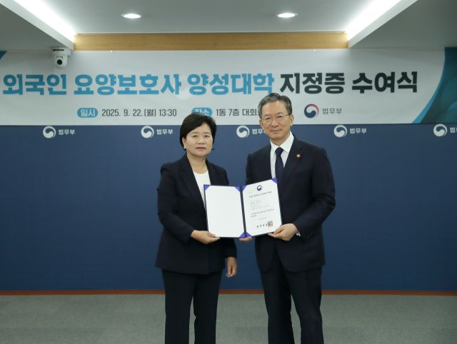 양영희 서정대 총장(왼쪽)이 정성호 법무장관으로터 법무부 주관 외국인 요양보호사 양성대학 인증서를 받은 뒤 기념사진을 찍고 있다. 서정대 제공