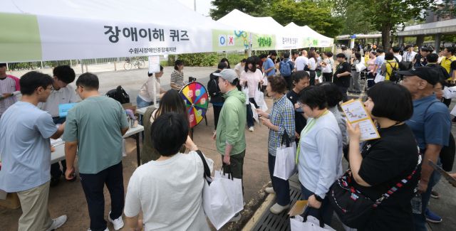 25일 오후 수원특례시 광교호수공원 마당극장에서 열린 '제14회 장애인과 비장애인이 함께하는 걷기대회'에서 다양한 부스를 체험하고 있다. 윤원규기자