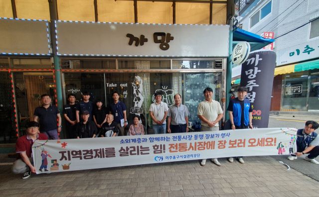 최근 인천 미추홀구 용현시장에서 열린 ‘전통시장 동행 장보기’ 행사에서 참가자들이 기념촬영을 하고 있다. 미추홀구 제공