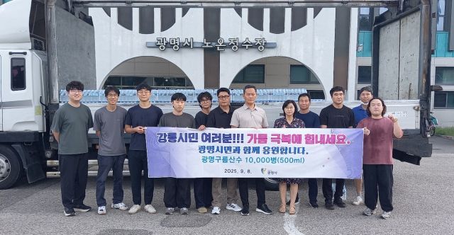 8일 오전 광명시 노온정수장 앞에서 직원들이 강릉으로 배송할 병입 수돗물 '구름산수'를 배경으로 기념사진을 촬영하고 있다. 광명시 제공