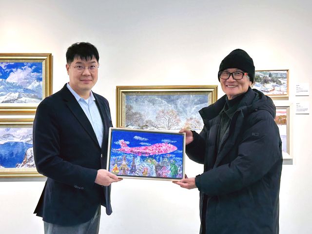 과천에 있는 장애예술인 전문 전시관 ‘갤러리바다’에서 오효석 작가(오른쪽)가 에어프레미아 임직원에게 작품을 선물하고 있다. 에어프레미아 제공