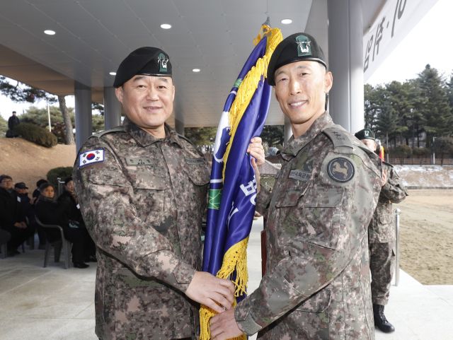 한기성 1군단장(왼쪽)이 최원석 신임 9사단장에게 사단기를 전달하고 있다. 9사단 제공