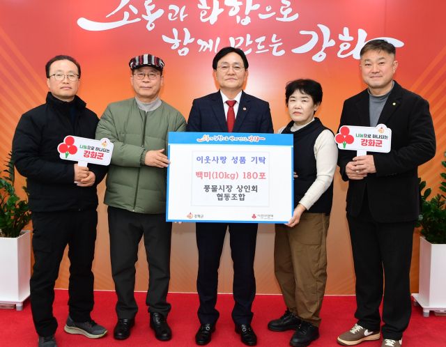 강화 풍물시장상인회협동조합 관계자들이 쌀을 기탁한 뒤 박용철 강화군수(가운데)와 함께 기념촬영을 하고 있다. 강화군 제공