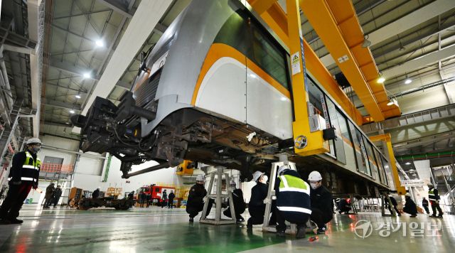 21일 인천 남동구 인천교통공사 운연차량사업소 정비창에서 중정비팀 직원들이 2호선 전동차 차체(객실)의 중정비를 위해 차체받침대에 고정하고 있다.