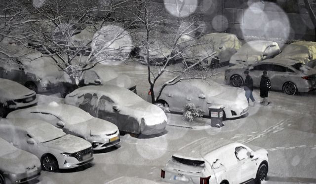 23일 밤 서울 인천시 남동구 한 아파트 단지에서 시민들이 내리는 눈을 맞으며 발걸음을 재촉하고 있다.