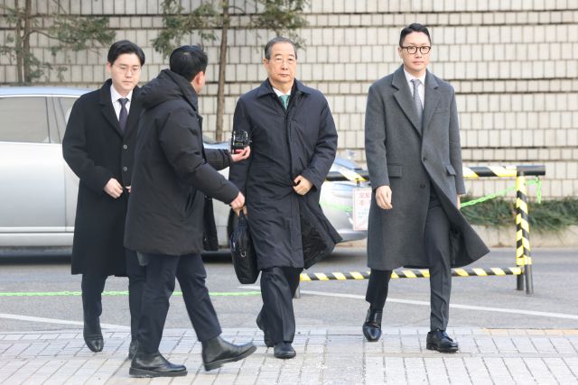 내란 중요임무 종사 혐의를 받는 한덕수 전 국무총리가 21일 서울중앙지법에서 열린 1심 선고 공판에 출석하고 있다. 한 전 총리는 이날 징역 23년을 선고받았다. 연합뉴스