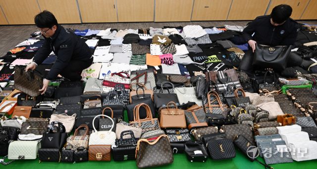 27일 인천 중구 관세청 인천본부세관에서 세관 직원들이 위조 명품 온라인 쇼핑몰 운영조직으로부터 압수한 위조 상품을 정리하고 있다.