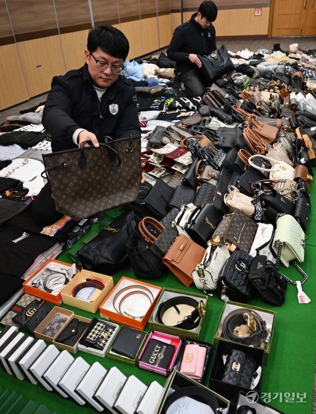 27일 인천 중구 관세청 인천본부세관에서 세관 직원들이 위조 명품 온라인 쇼핑몰 운영조직으로부터 압수한 위조 상품을 정리하고 있다.