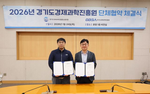 경기도경제과학진흥원 김현곤 경과원장과 권혁규 노동조합 위원장이 29일 본원 1층 비전실에서 진행된 노사 단체협약 체결식에서 협약서에 서명하고 기념촬영하고 있다. 경과원 제공