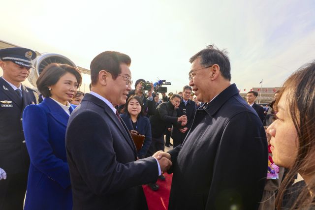 중국을 국빈방문한 이재명이 4일 베이징 서우두 공항에서 환영 나온 인허쥔 중국 과학기술부장(장관)과 인사하고 있다. 연합뉴스