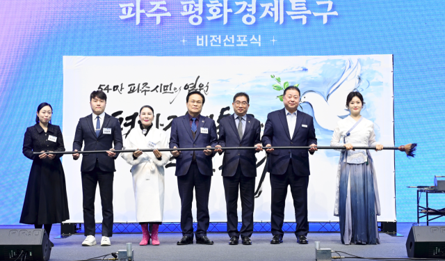 7일 오후 파주시민회관 대공연장에서 열린 ‘파주 평화경제특구 비전 선포식’에서 김경일 시장이 참석자들과 테이프를 자르고 있다. 파주시 제공