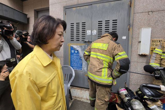 추미애 경기도지사가 16일 경기 부천시 한 금속 도장공장 화재 현장을 찾아 동료 부상으로 슬퍼하는 소방대원의 뒷모습을 바라보고 있다. 연합뉴스