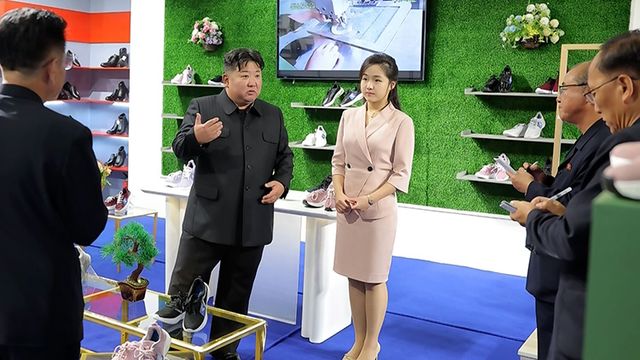 김정은 북한 국무위원장이 지난 19일 '전국피복, 신발전시회-2026'을 찾아 신발 전시대에서 딸 주애가 지켜보는 가운데 간부들과 이야기하고 있다. 조선중앙통신=연합뉴스