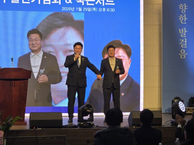 ‘이천을 향한 발걸음’ 출판기념회에서 성수석 더불어민주당 이천시지역위원장과 엄태준 전 시장이 손을 맞잡고 있다. 성수석 위원장 제공