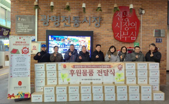 광명전통시장 관계자들이 9일 광명전통시장에서 '설맞이 이웃사랑 떡만둣국 세트 나눔 행사'를 진행하고 기념촬영을 하고 있다. 광명시 제공