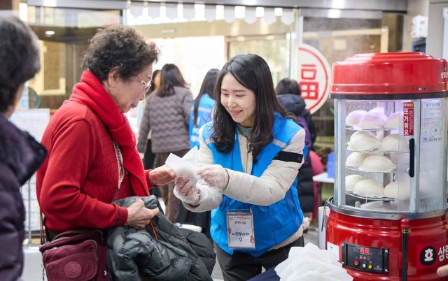 ▲11일 서울시 서초구 양재노인종합복지관에서 상미당홀딩스 해피봉사단이 설 명절을 맞아 관내 어르신들에게 호빵을 나누고 있다. 사진=상미당홀딩스 제공