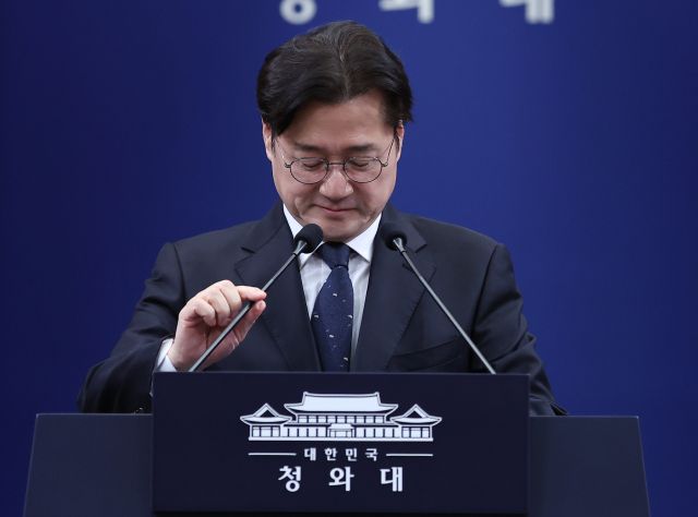 홍익표 정무수석이 12일 청와대 춘추관에서 이날 예정됐다 취소된 이재명 대통령과 더불어민주당 정청래 대표, 국민의힘 장동혁 대표 오찬 관련 브리핑을 하기 전 마이크 위치를 조정하고 있다. 연합뉴스