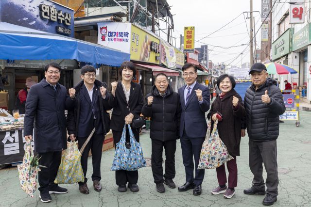 김학기 의왕시의회 의장(오른쪽 세 번째)과 의원들이 부곡도깨비시장을 방문해 전통시장 장보기 행사를 진행한 뒤 기념촬영을 하고 있다. 의왕시의회 제공
