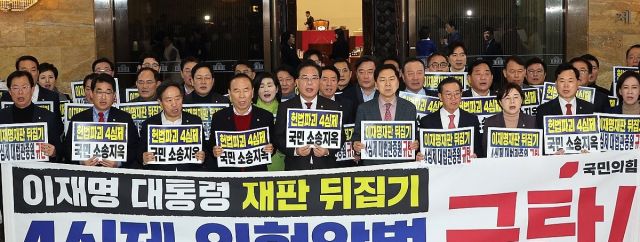 국민의힘 송언석 원내대표 등 의원들이 12일 국회 로텐더홀에서 '4심제 위헌 악법 규탄' 대회를 열고 구호를 외치고 있다. 연합뉴스