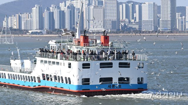 설 연휴 마지막 날인 18일 인천 중구 월미도 선착장에서 영종도 구읍뱃터로행 여객선에 승선한 나들이객들이 갈매기들에게 먹이를 주고 있다. 조병석기자