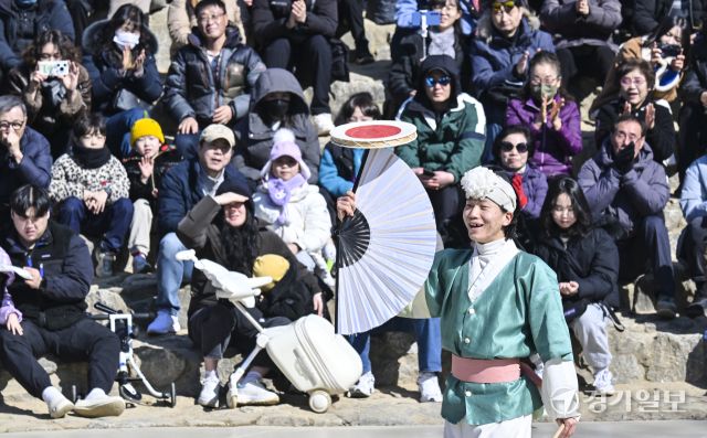 설 연휴 마지막날인 18일 오후 용인특례시 기흥구 한국민속촌에서 관광객들이 '삼도판굿' 공연을 보며 즐거운 나날을 보내고 있다. 홍기웅기자