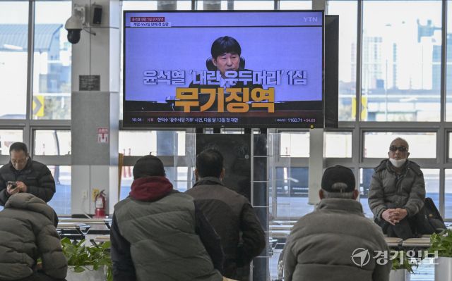 19일 오후 오산역버스환승센터에서 시민들이 TV로 중계되는 윤석열 전대통령의 내란우두머리죄 1심 선고 판결을 시청하고 있다. 홍기웅기자