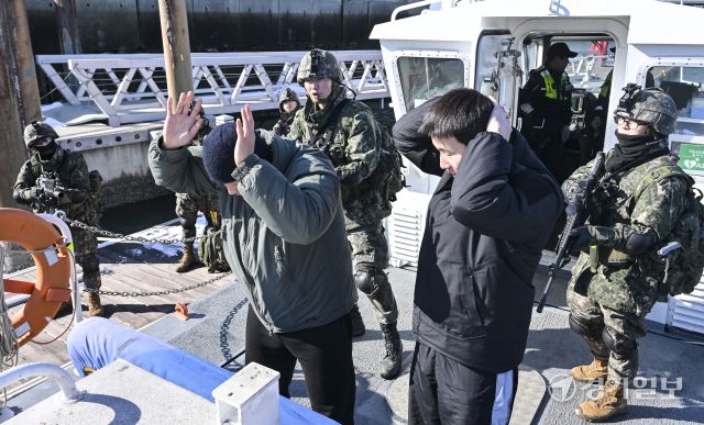 육군 제51보병사단 비봉여단이 2일 오후 화성특례시 제부마리나 일대에서 26년 혹한기 훈련 일환으로 군-경 합동 밀입국 대응 FTX훈련을 진행했다. 사진은 제51보병사단 장병과 평택해양경찰서 관계자들이 선박위에서 합동으로 밀입국자 검문 및 체포하는 모습. 홍기웅기자