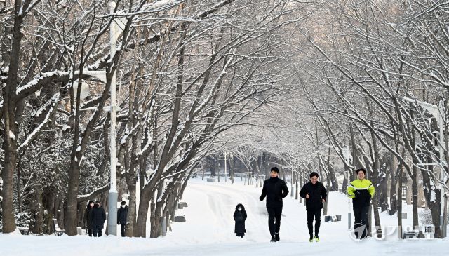 밤사이 눈이 내린 2일 인천 남동구 인천대공원을 찾은 시민들이 눈길을 걷고 있다. 조병석기자
