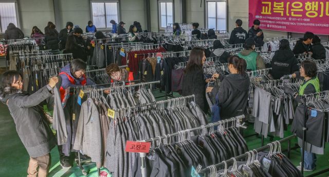 21일 안산시 산업지원본부 교복상설매장에서 열린 ‘교복 나눔 행사’를 찾은 학부모와 학생들이 교복을 살펴보고 있다. 안산시는 이번 행사를 통해 교복 구매 부담을 덜고 자원 순환 문화를 확산한다는 계획이다.조주현기자