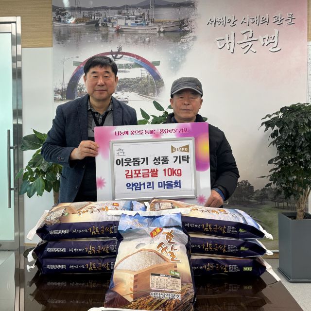 대곶면 약암1리 마을회 관계자가 김포금쌀을 기탁하며 김영대 면장(왼쪽)과 기념사진을 촬영하고 있다. 대곶면 제공