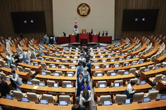 우원식 국회의장이 지난12일 국회에서 열린 2월 임시국회 본회의에서 산회를 선포한 뒤 한복을 입은 의원들이 본회의장을 떠나고 있다. 연합뉴스
