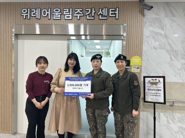 국군의무사령부가 위례어울림주간센터를 방문해 장애인 복지 증진을 위한 후원금을 전달한 뒤 관계자들과 기념촬영을 하고 있다. 위례어울림주간센터 제공