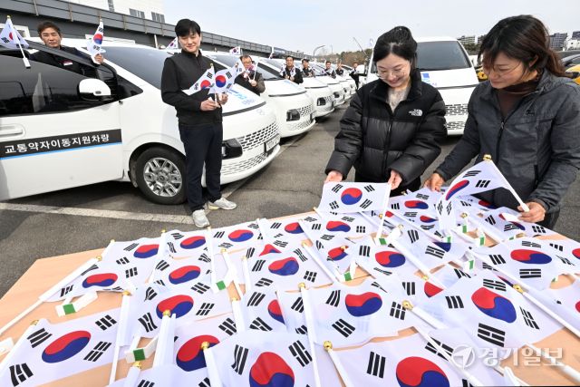 3·1절을 사흘 앞둔 26일 오후 수원시교통약자이동지원센터에서 수원도시공사 관계자들이 교통약자이동지원차량인 ‘한아름콜택시’에 태극기를 부착하고 있다. 김시범기자