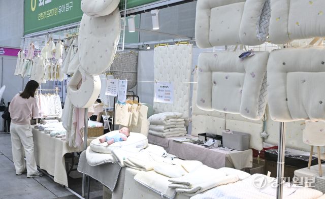 6일 오후 수원특례시 영통구 수원컨벤션센터에서 열린 '2026 수원광교 베이비페어+유아교육전'에서 참관객이 영유아를 위한 의류 등을 살펴보고 있다. 150여개의 부스가 참여한 이번 행사는 8일까지 진행된다. 홍기웅기자