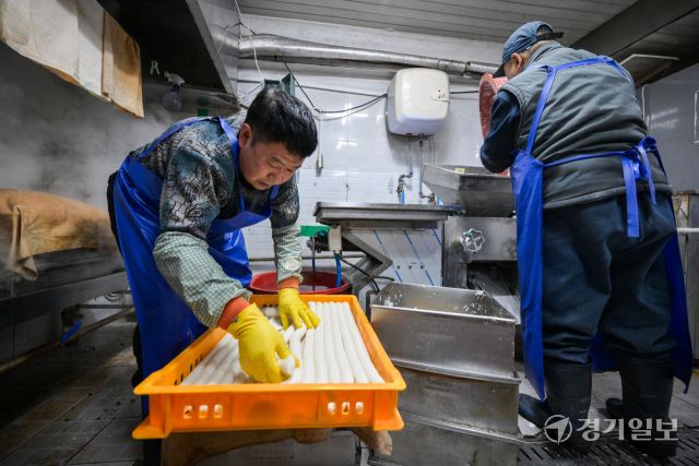 8일 오후 설 대목을 맞은 수원특례시 팔달구 한 전통시장 내 방앗간에서 직원들이 떡국용 가래떡을 뽑느라 분주히 움직이고 있다. 윤원규기자