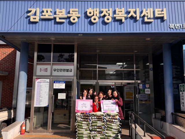 김포농협 여성산악회 회원들이 백미를 기탁하며 기념촬영을 하고 있다. 김포본동행정복지센터 제공