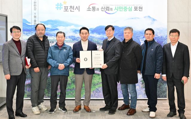 백영현 포천시장이 ‘윤세징 일가 묘역 및 석물’ 향토유산 지정서 수여식에서 파평윤씨 종중 윤경환 회장에게 지정서를 전달한 뒤 관계자 등과 기념촬영을 하고 있다. 포천시 제공