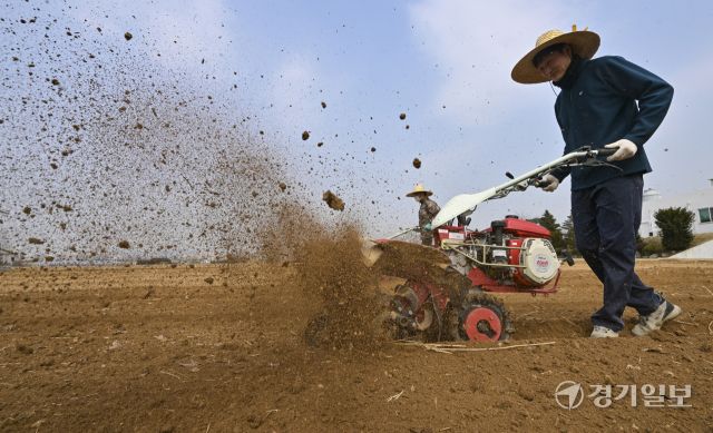 흙의 소중함을 알리고 건강한 토양 보전을 위해 제정된 ‘흙의 날’인 11일 오전 화성특례시 병점구 경기도농업기술원 연구용 밭에서 관계자들이 겨우내 창고에 보관했던 트랙터와 로터리 등 농기계를 점검하고 있다. 홍기웅기자